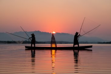 A stunning shot of two fishermen in Vietnam at sunset 