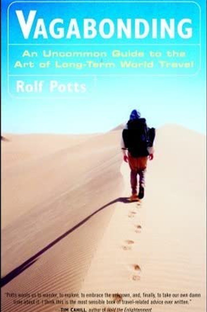 Vagabonding book cover - man walking across sand dunes with blue sky