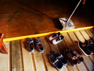 A photo of five pairs of shoes on wooden decking 