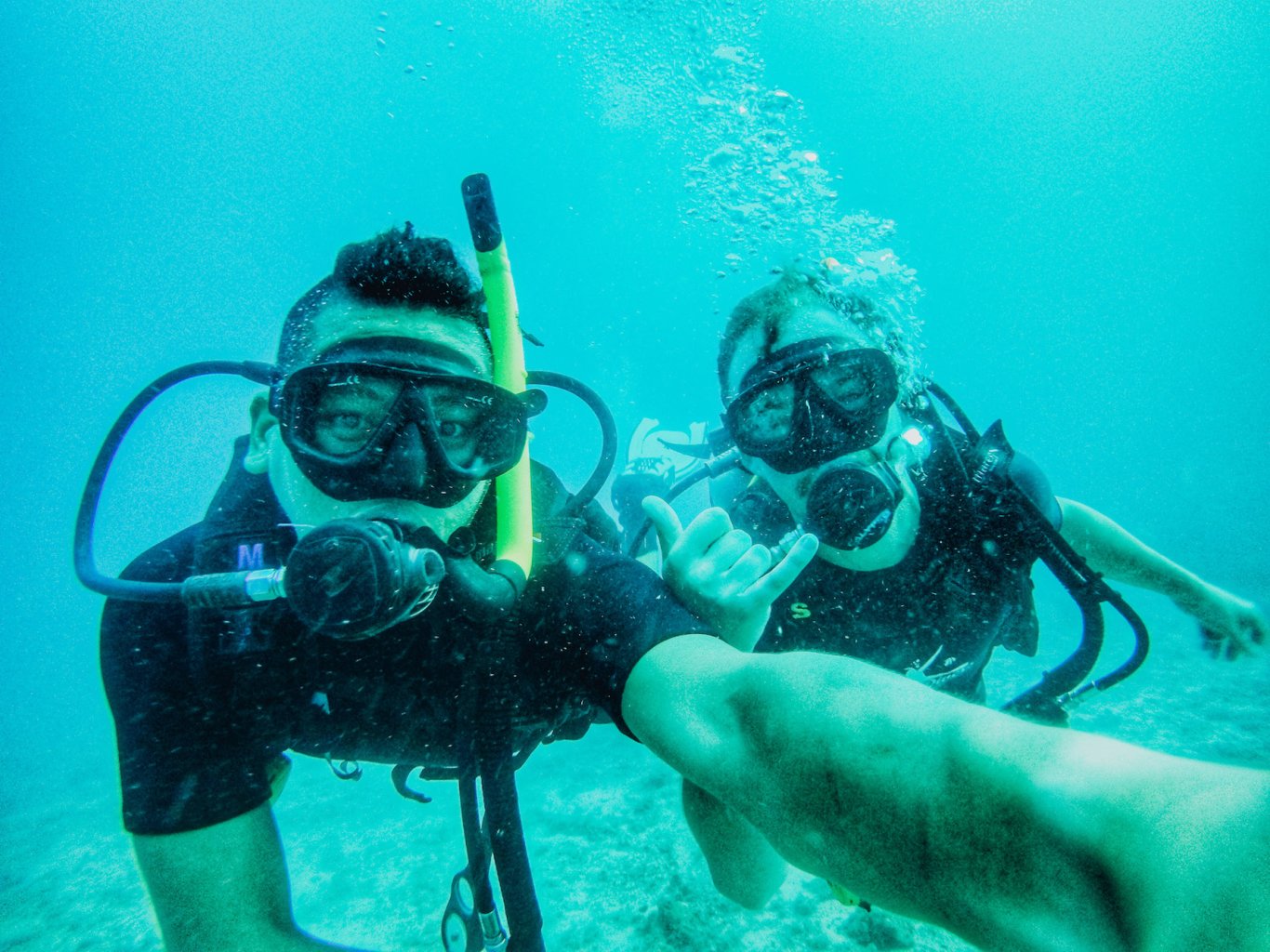 Two scuba divers underwater taking selfie 