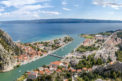 An aerial view of Omis in Croatia, showing the lush green landscape and the town