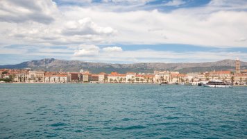 A photo of Split, Croatia from the sea showing the town and the mountain landscapes in the background