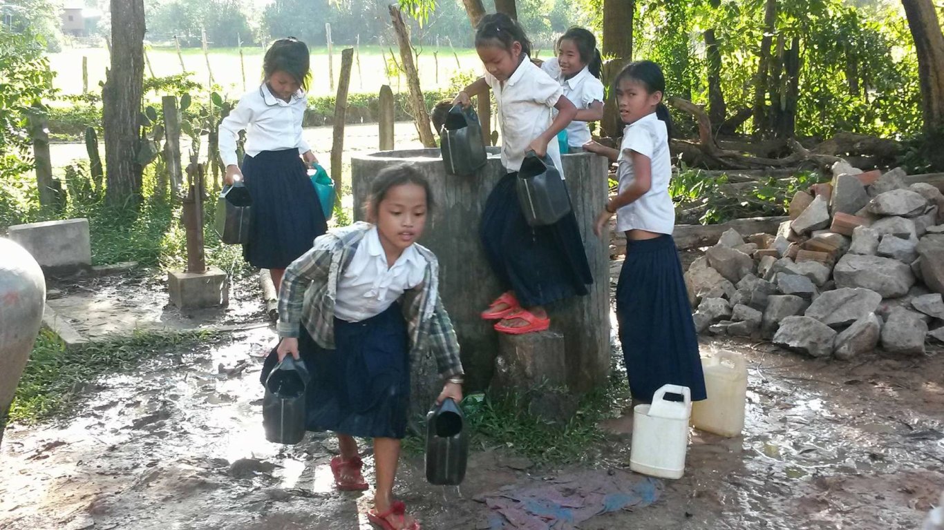 Cambodia water well - girls helping building the well