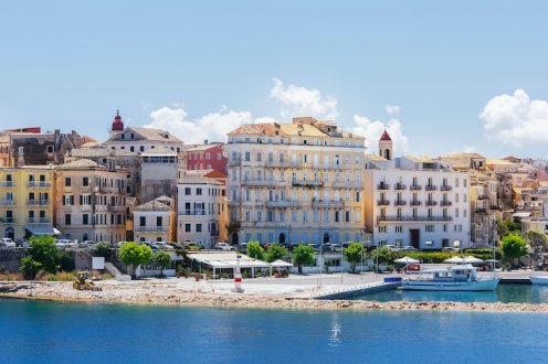 View of the houses along the white sandy beach in Corfu town, Greece