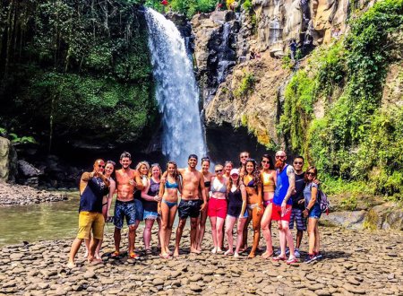 Group of travellers standing in front of waterfall 