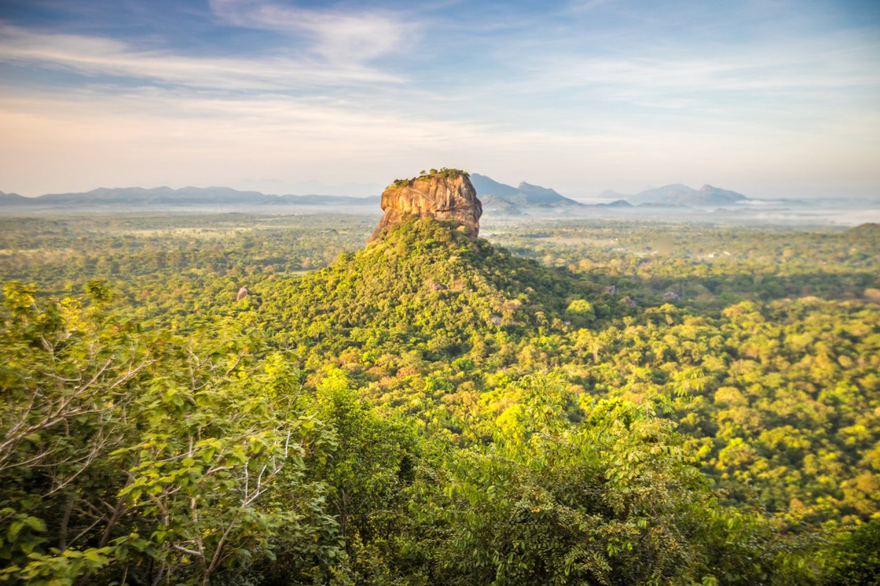View of Sigiriya rock in the distance surrounded by green trees