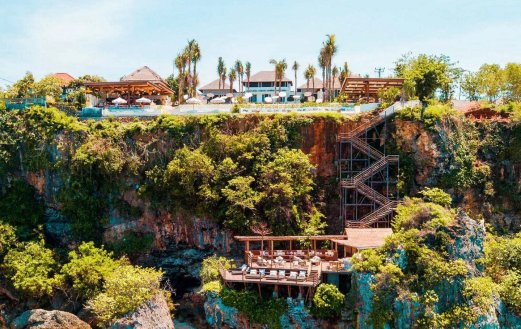 An image of the stunning Ulu cliffhouse beach club in Bali, Indonesia showing the lush greenery surrounding the beach club