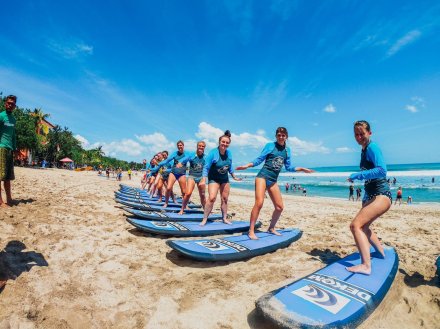 A group practicing their surf board moves on the beach before going into the sea in Bali, Indonesia 