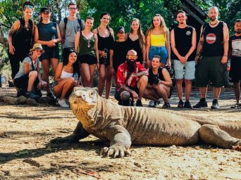 komodo dragon with group of travellers behind