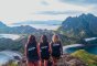 Three girls standing at the top of the viewpoint on Padar Island, admiring the view of the mountainous landscape and bays in the distance in Indonesia