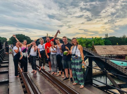 Group standing on the bridge over the river Kwai in Kanchanaburi Thailand