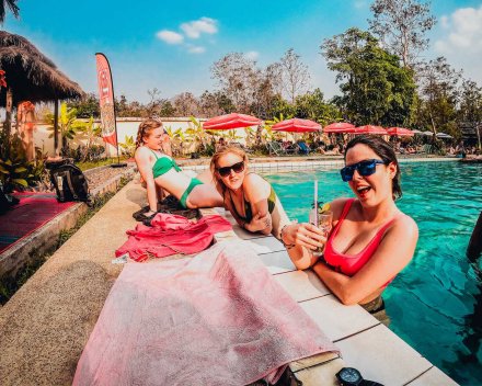 3 girls chilling by a pool in Thailand having drinks
