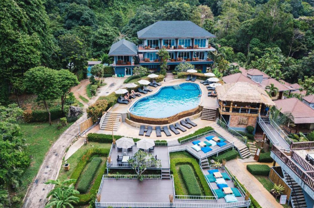 A drone shot of the hotel grounds in Railay beach, Krabi, Thailand showing the pool, sun loungers, bean bags and luscious surrounding greenery