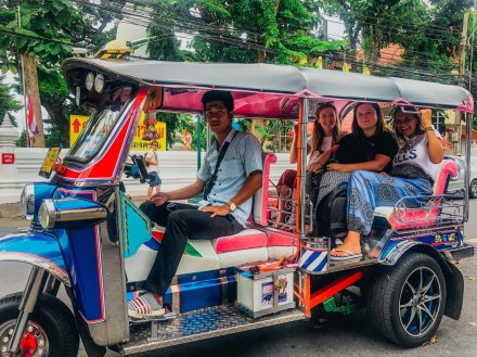 A trio taking a tuk tuk ride through Bangkok Thailand 